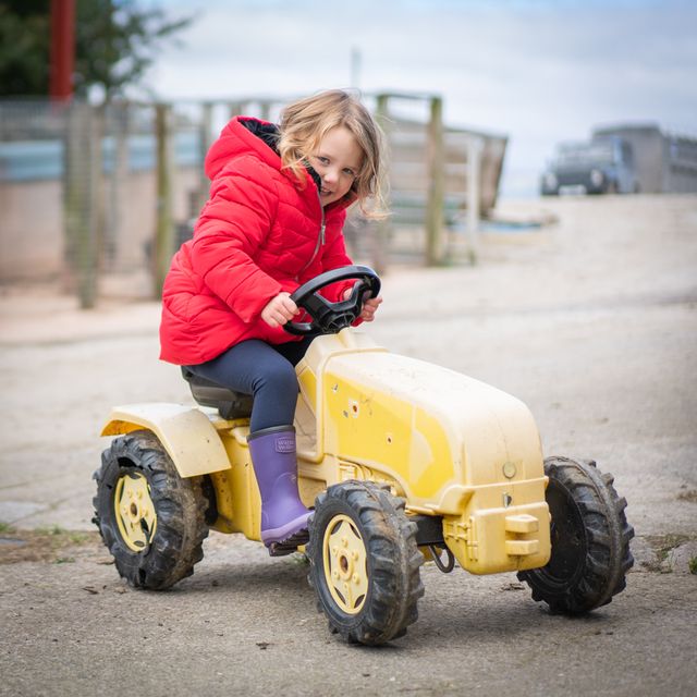 Girl in warm wellies on tractor